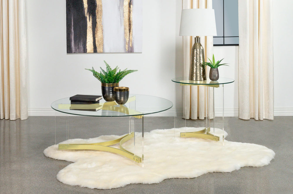 Mesa de centro Janessa redonda con tapa de vidrio y patas acrílicas, latón mate