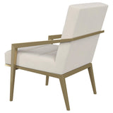 Sillón decorativo Kirra con brazos de metal tapizados en color crema