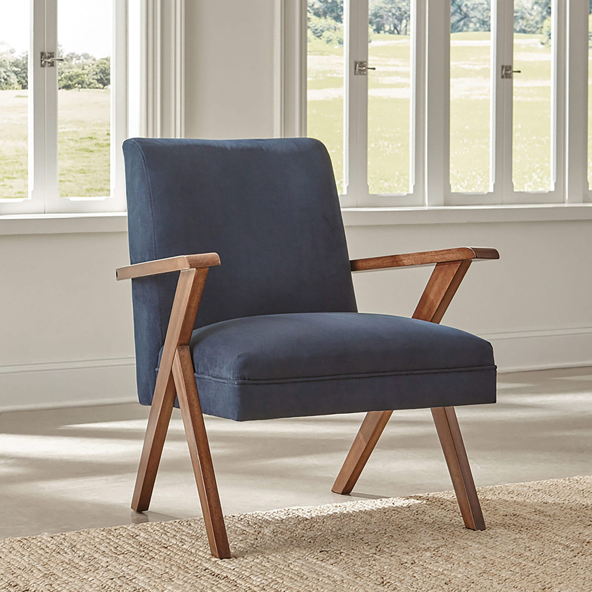 Sillón Cheryl con brazos de madera tapizados, color azul oscuro